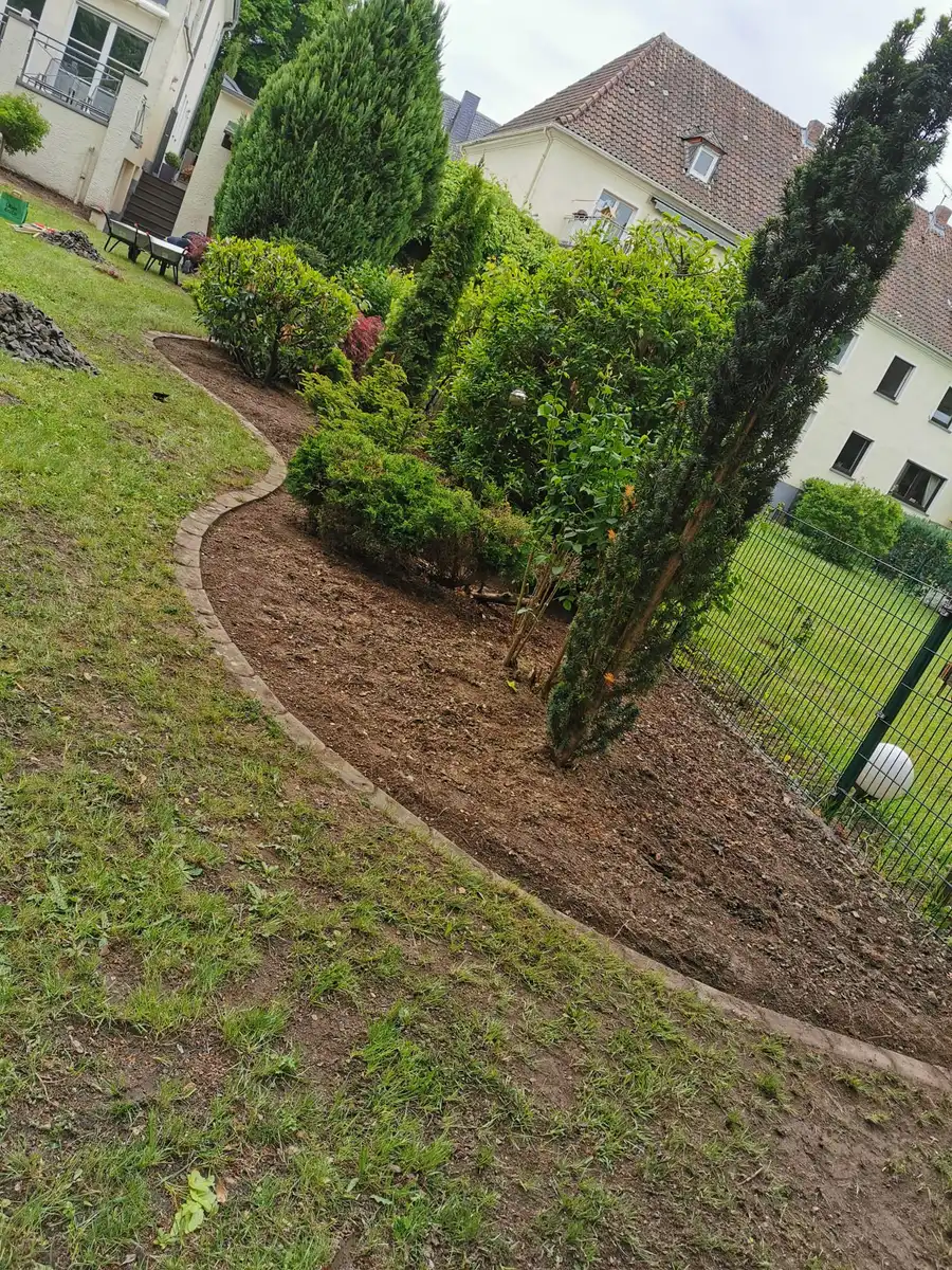 Neu angelegtes Gartenbeet mit Rindenmulch und sauberer Beeteinfassung