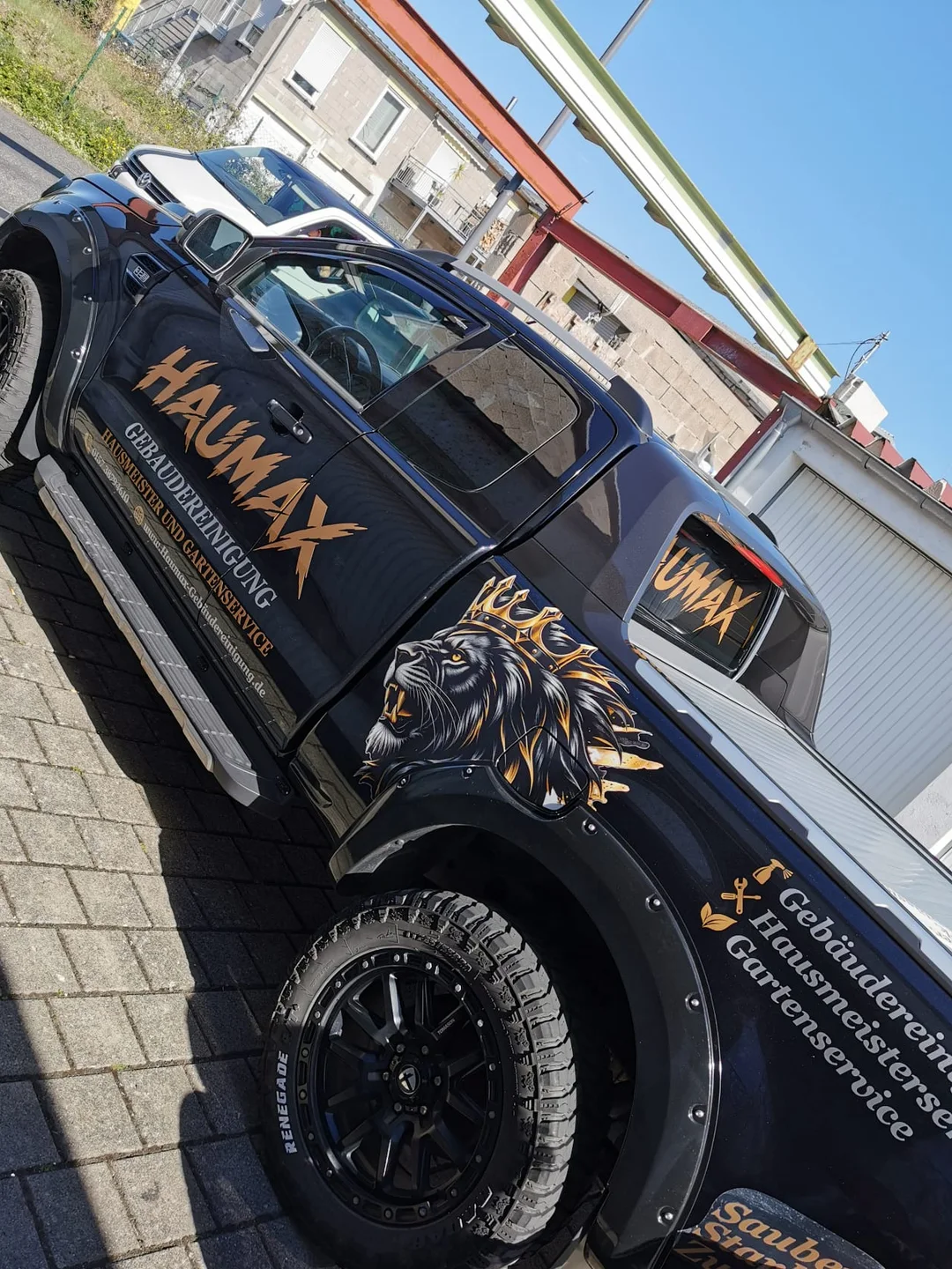 Haumax-Pickup mit goldener Beschriftung, Löwenwappen und den drei Bereichen Gebäudereinigung, Hausmeisterservice und Gartenservice